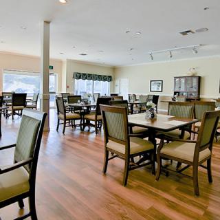 A spacious and well-lit dining room with multiple tables and chairs arranged neatly.