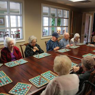 A group of seniors enjoying a game of bingo in a community room.