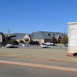 A view of a residential area with parked cars and clear blue skies.