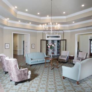 Elegantly decorated living room with comfortable seating and a central chandelier.