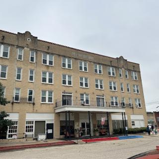 A historic hotel building showcasing classic architectural features under a cloudy sky.