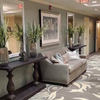 A beautifully decorated lobby with a comfortable sofa, elegant decor, and lush greenery.