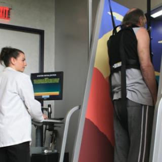 A physical therapy session in progress, with a healthcare professional monitoring a patient using specialized exercise equipment.
