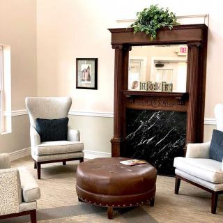 A cozy living room featuring a fireplace, comfortable chairs, and a central coffee table.