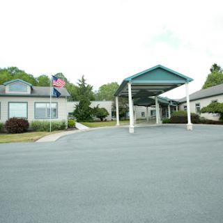 An entrance view of a building featuring a covered walkway and flags.