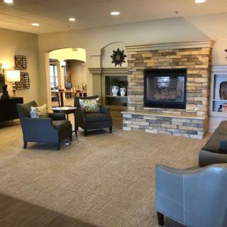 A cozy living room with comfortable seating and a stone fireplace.