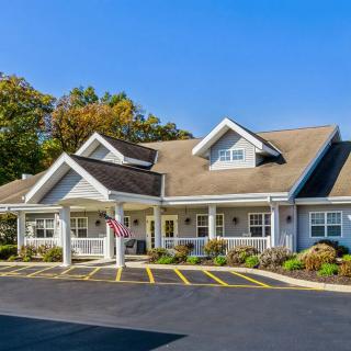 A charming suburban house with a spacious driveway and surrounding trees.