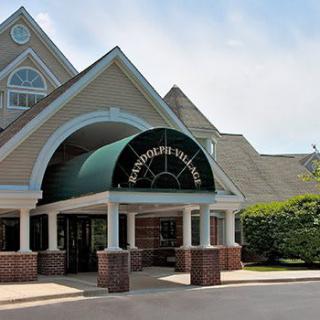Entrance to a building with a green awning and brick facade.