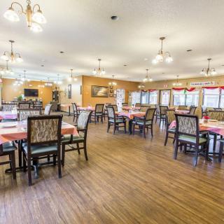 A spacious dining area with neatly arranged tables and chairs, well-lit by overhead lights.