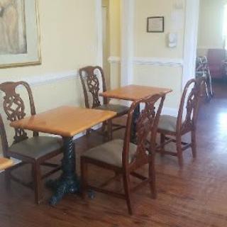 An empty dining area with wooden tables and chairs.