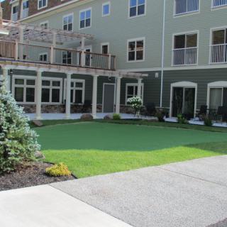 A well-maintained lawn area in front of a modern multi-story building.