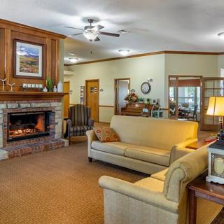 A cozy living room with a fireplace, featuring comfortable sofas and warm lighting.
