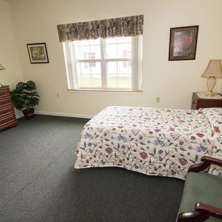 A cozy bedroom with a bed, window, and classic decor.