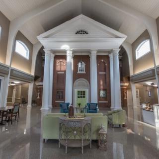 A spacious and elegant lobby featuring high ceilings, classic columns, and comfortable seating areas.