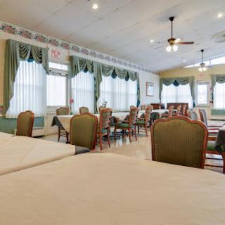 A spacious and well-lit dining room setting with neatly arranged tables and chairs.