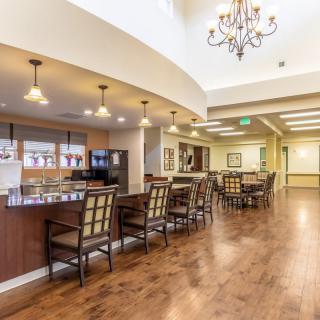 A modern dining area featuring a chandelier and wooden flooring.