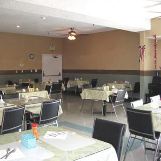 An empty dining room with neatly arranged tables and chairs, ready for service.