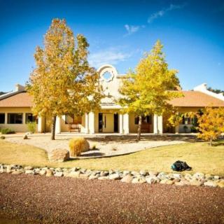 A beautiful house surrounded by autumn foliage under a clear blue sky.