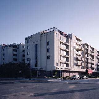 A modern multi-story residential building on a city street corner.