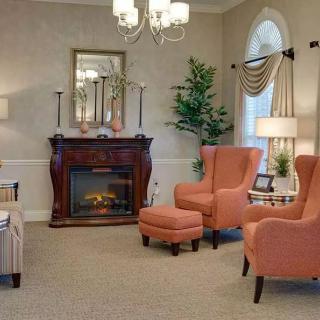 A cozy living room featuring a fireplace, elegant chairs, and tasteful decor.