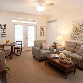 A cozy living room with a sofa, coffee table, small dining area, and tasteful decor.