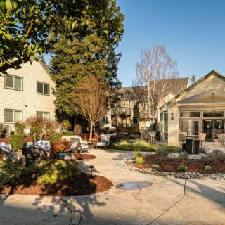 A scenic view of a landscaped garden area with patios and surrounding buildings.