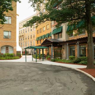 A view of a building entrance with an awning and surrounding trees.