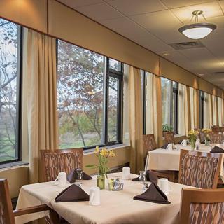 A cozy restaurant dining area with neatly set tables and large windows.