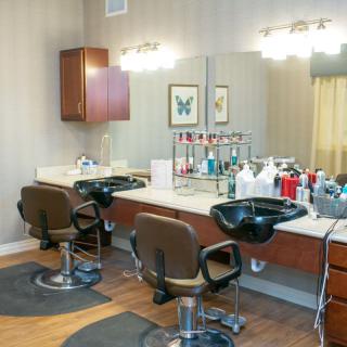 A well-equipped beauty salon with styling chairs and hair care products.