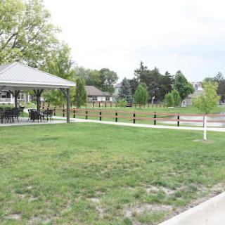 A peaceful park featuring a gazebo surrounded by lush green grass.