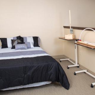 A minimalist bedroom featuring a neatly made bed and sleek furniture.