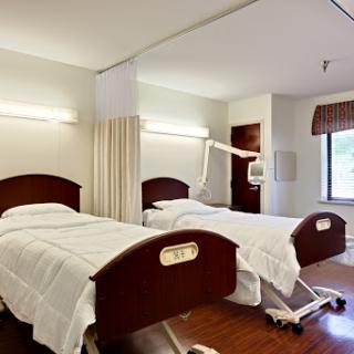 A clean and modern hospital patient room with two adjustable beds.