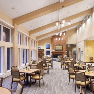A spacious dining area with wooden furniture and natural lighting.