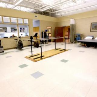 A physical therapy room equipped with parallel bars and other rehabilitation facilities.