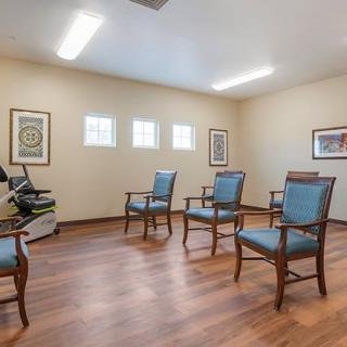 A small meeting room with wooden chairs and framed artwork on the walls.