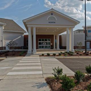 A building entrance with prominent pillars and a well-maintained pathway.