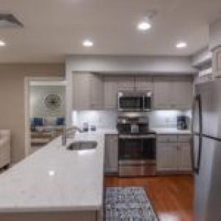 Modern kitchen with stainless steel appliances and a marble countertop.