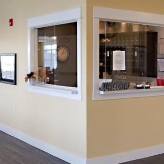 A reception area with yellow walls, featuring a counter and windows.