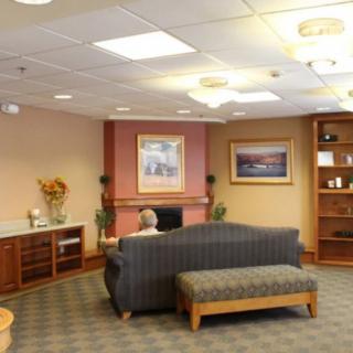 A cozy lobby area featuring a sofa, shelves, and wall art.
