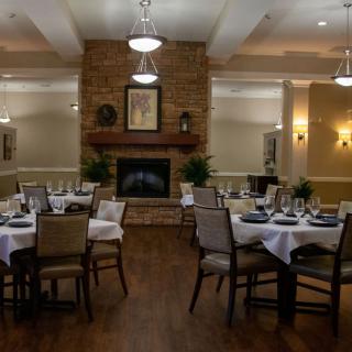 Elegant dining room with neatly set tables and a cozy fireplace.