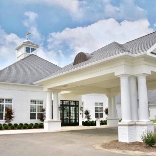 A modern white building with a grand entrance supported by columns.