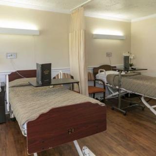 A hospital room with two patient beds and medical equipment.
