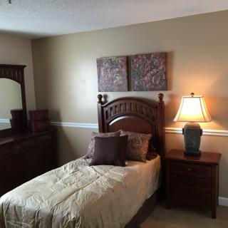 A cozy bedroom with a single bed and wooden furniture.
