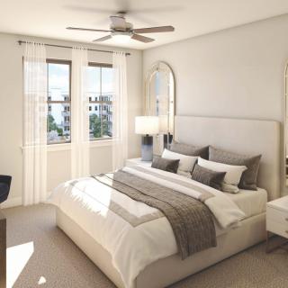 A modern bedroom with neutral colors and abundant natural light.