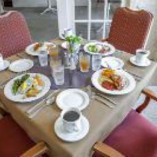 A dining table set with plates of food and beverages, ready for a meal.