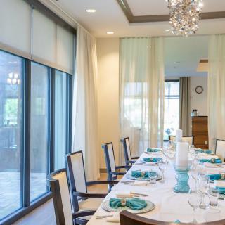 Elegant dining room with a beautifully set table and large windows letting in natural light.