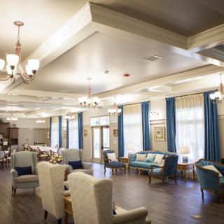 A spacious and elegantly decorated lounge area with comfortable seating and chandeliers.