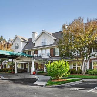 A welcoming hotel entrance surrounded by trees and landscaping.