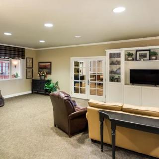 A cozy living room featuring comfortable seating and a wall-mounted TV.