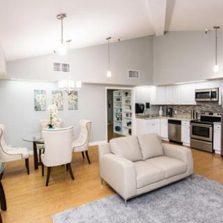 A modern open floor plan living space featuring a kitchen, dining area, and cozy seating.